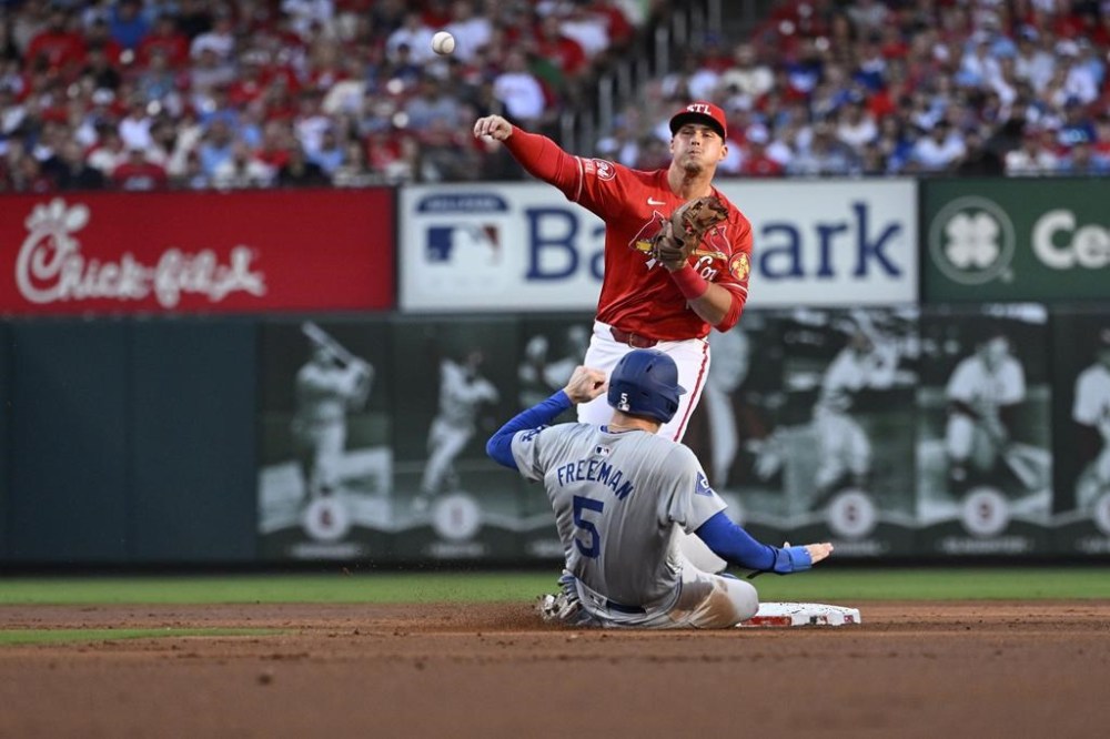 Los Angeles Dodgers' Freddie Freeman (5) is out at second as St. Louis Cardinals second baseman Nolan Gorman, top, throws to first on a double play-attempt against Will Smith during the firsts inning of a baseball game Saturday, Aug. 17, 2024, in St. Louis. (AP Photo/Jeff Le)