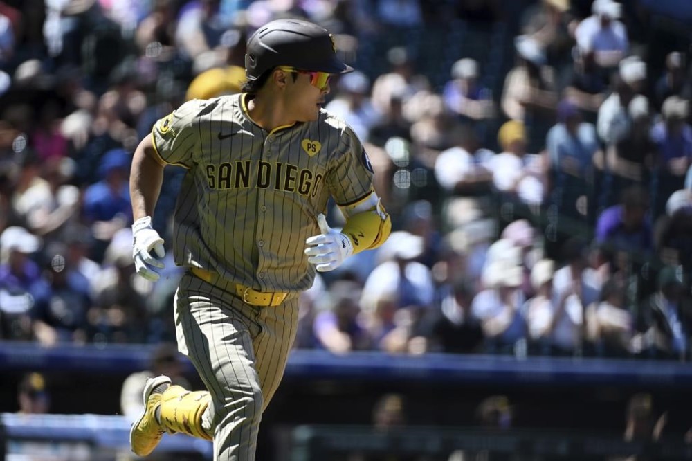 San Diego Padres' Ha-Seong Kim runs to first base after hitting a single in the third inning of a baseball game against the Colorado Rockies, Sunday, Aug. 18, 2024, in Denver. (AP Photo/Geneva Heffernan)