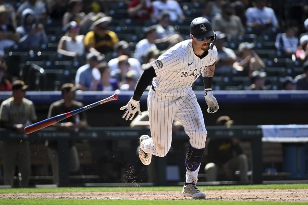 Colorado Rockies' Brenton Doyle throws his bat after hitting a triple in the sixth inning of a baseball game against the San Diego Padres, Sunday, Aug. 18, 2024, in Denver. (AP Photo/Geneva Heffernan)