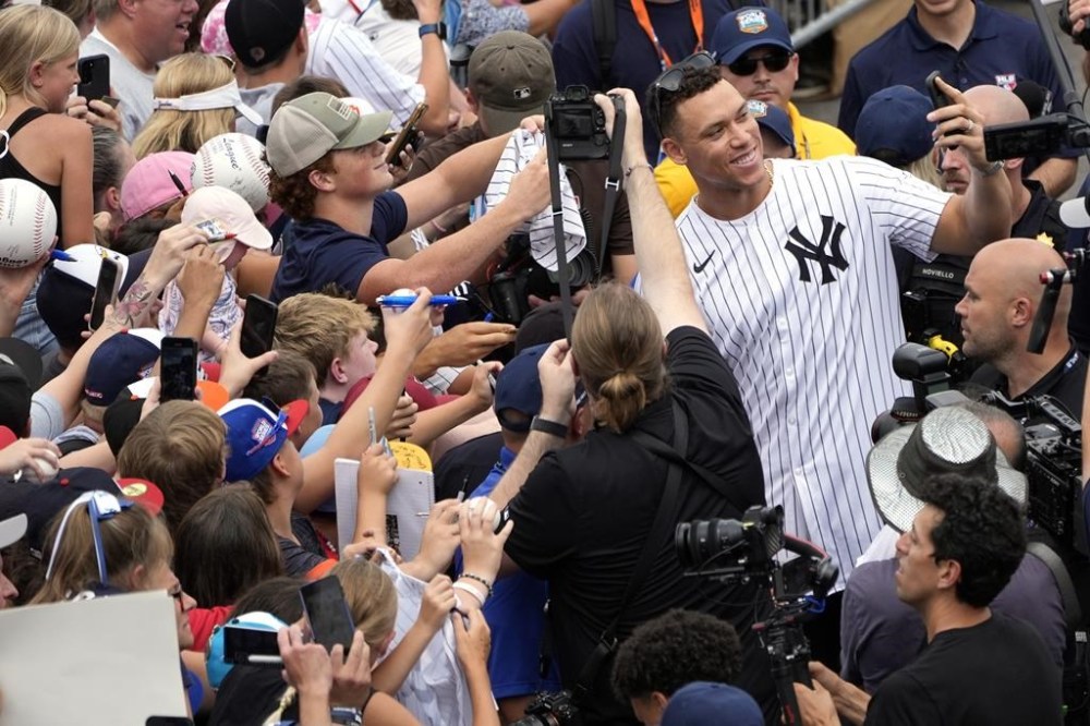 New York Yankees' Aaron Judge takes a selfie with a fan's cell phone as he arrives with the New York Yankees arrive at the Little League World Series Complex to watch the Little League World Series tournament in South Williamsport, Pa., Sunday, Aug. 18, 2024. (AP Photo/Tom E. Puskar)
