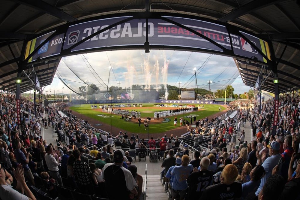 The New York Yankees line the third baseline and the Detroit Tigers line the first baseline, as the 20 Little League teams participating in the Little League World Series line the infield during the National Anthem before the Little League Classic baseball game at Bowman Field in Williamsport, Pa., Sunday, Aug. 18, 2024. (AP Photo/Gene J. Puskar)