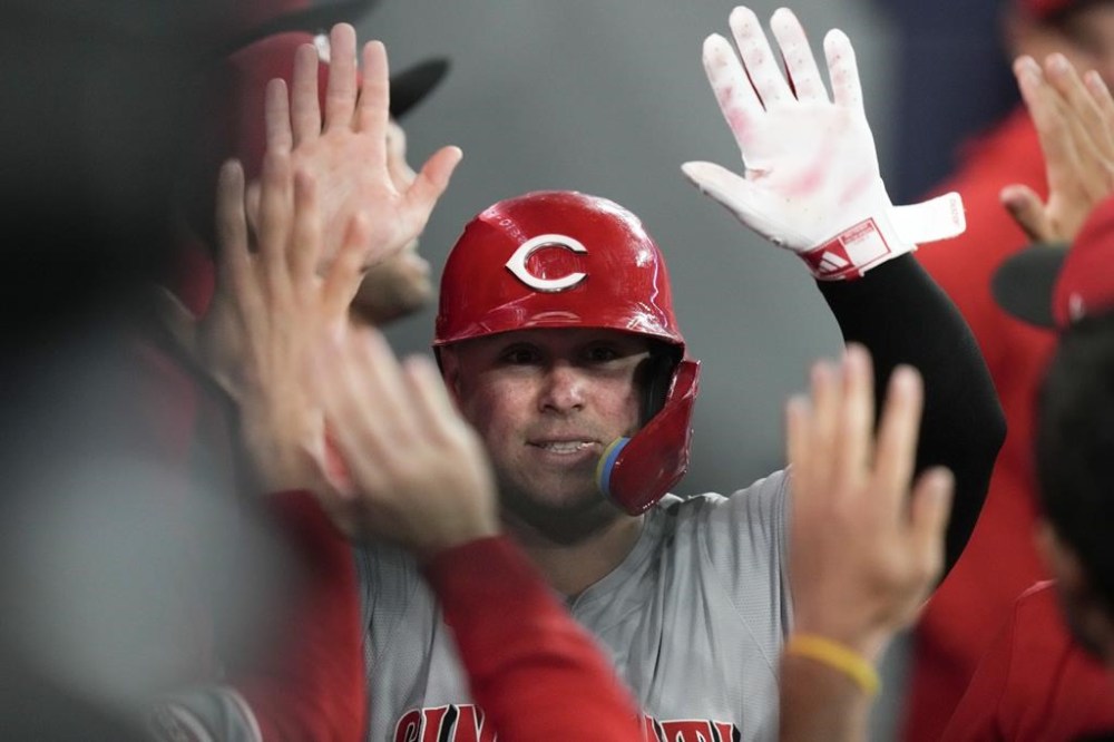 Cincinnati Reds Ty France celebrates in the dugout after scoring off an RBI double from Reds Jake Fraley during sixth inning Interleague MLB baseball action against Toronto Blue Jays in Toronto on Monday Aug. 19, 2024. THE CANADIAN PRESS/Chris Young