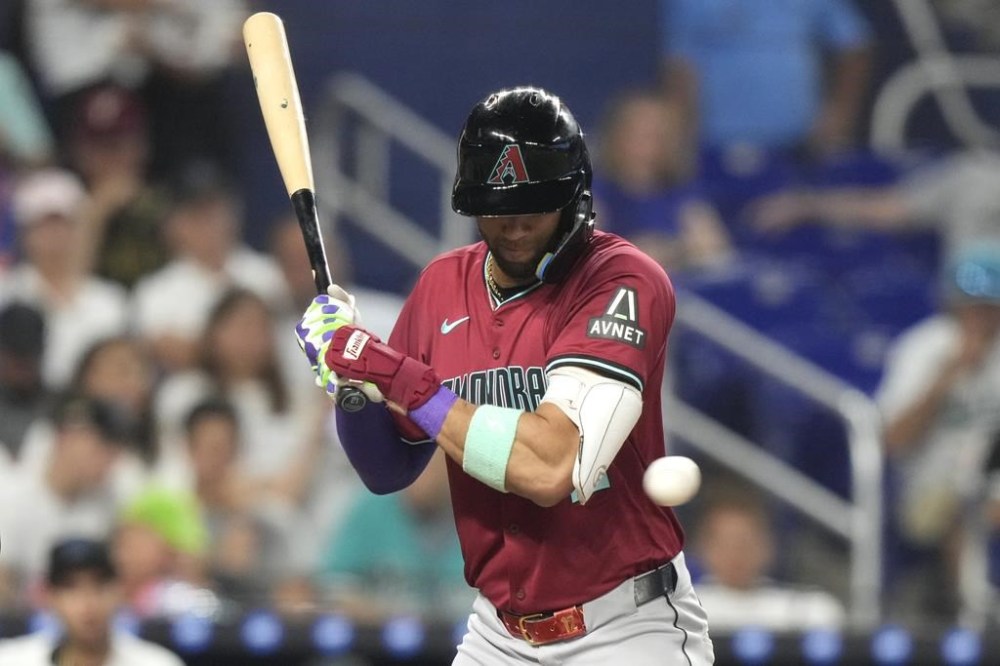 Arizona Diamondbacks' Lourdes Gurriel Jr. is hit by a pitch thrown by Miami Marlins starting pitcher Adam Oller during the third inning of a baseball game, Monday, Aug. 19, 2024, in Miami. (AP Photo/Lynne Sladky)