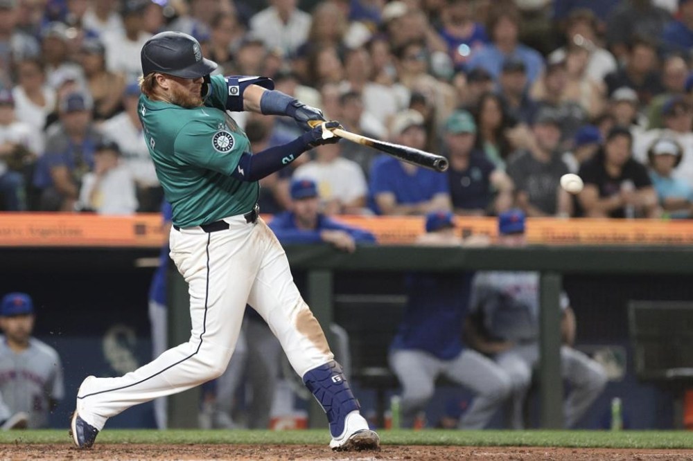 Seattle Mariners' Justin Turner follows through on an RBI single off a pitch by New York Mets pitcher Phil Maton during the seventh inning of a baseball game, Saturday, Aug. 10, 2024, in Seattle. (AP Photo/Jason Redmond)