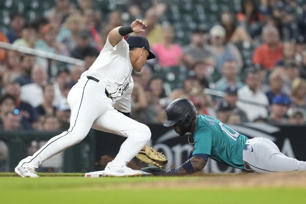 Seattle Mariners' Victor Robles (10) slides safely into third base as Detroit Tigers third base Gio Urshela (13) is late with the tag in the eighth inning of a baseball game, Wednesday, Aug. 14, 2024, in Detroit. (AP Photo/Paul Sancya)