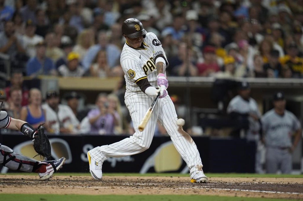 San Diego Padres' Manny Machado hits a two-run home run during the seventh inning of a baseball game against the Minnesota Twins, Tuesday, Aug. 20, 2024, in San Diego. (AP Photo/Gregory Bull)