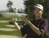FILE - Davis Love III holds the trophy after winning the International at Castle Pines, Sunday, Aug. 10, 2003, in Castle Rock, Colo. (AP Photo/Jack Dempsey, File)