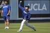 Los Angeles Dodgers starting pitcher Yoshinobu Yamamoto, right, throws in the outfield as interpreter Yoshihiro Sonoda, left, looks on prior to a baseball game against the Pittsburgh Pirates, Saturday, Aug. 10, 2024, in Los Angeles. (AP Photo/Jayne-Kamin-Oncea)