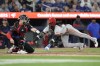 Cincinnati Reds Elly De La Cruz scores as he crosses the plate in front of Toronto Blue Jays catcher Brian Serven during fifth inning Interleague MLB baseball action in Toronto on Wednesday Aug. 21, 2024. THE CANADIAN PRESS/Chris Young