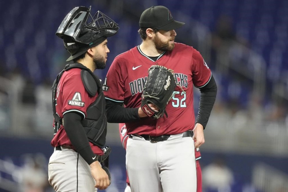 Arizona Diamondbacks catcher Adrian Del Castillo, left, talks with starting pitcher Jordan Montgomery, right, during the fourth inning of a baseball game against the Miami Marlins, Wednesday, Aug. 21, 2024, in Miami. (AP Photo/Lynne Sladky)