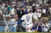 Los Angeles Dodgers designated hitter Shohei Ohtani scores off of a double hit by Mookie Betts during the third inning of a baseball game in Los Angeles, Wednesday, Aug. 21, 2024. Kevin Kiermaier also scored. (AP Photo/Ashley Landis)