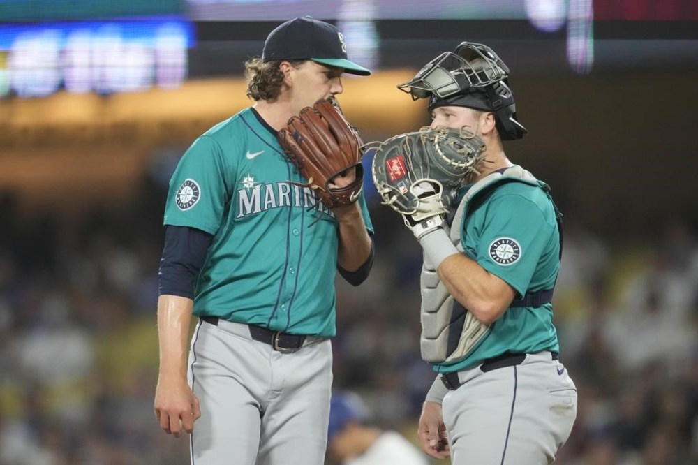 Seattle Mariners starting pitcher Logan Gilbert, left, and catcher Cal Raleigh conference on the mound during the third inning of a baseball game against the Los Angeles Dodgers in Los Angeles, Wednesday, Aug. 21, 2024. (AP Photo/Ashley Landis)
