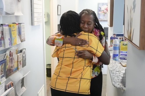 Marie Jean Denis, left, hugs Jennie Joseph, right, lead midwife and clinic director as she leaves after her appointment at the Commonsense Childbirth clinic Wednesday, June 26, 2024, in Orlando, Fla. (AP Photo/John Raoux)