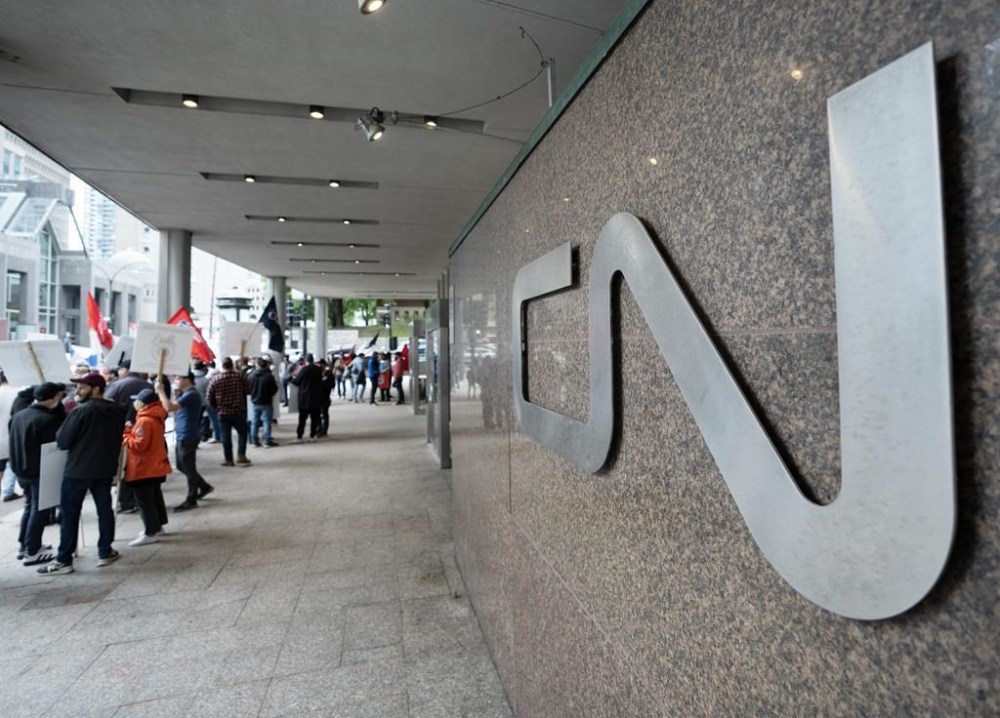 Rail workers picket in front of CN headquarters on the first day of a nationwide rail shutdown, after workers were locked out by CN and CPKC when new contract agreements weren't reached by the midnight deadline, in Montreal, Thursday, Aug. 22, 2024. THE CANADIAN PRESS/Ryan Remiorz