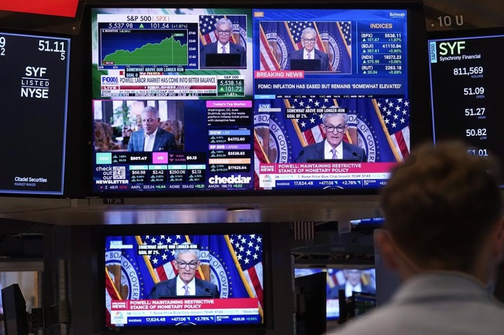 FILE - A bank of television screens on the floor of the New York Stock Exchange, shows Federal Reserve Chairman Jerome Powell, July 31, 2024. (AP Photo/Richard Drew., File)