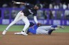 Miami Marlins second base Vidal Bruján, left, is unable to make the tag as Chicago Cubs' Dansby Swanson (7) steals second base during the fourth inning of a baseball game, Friday, Aug. 23, 2024, in Miami. (AP Photo/Wilfredo Lee)