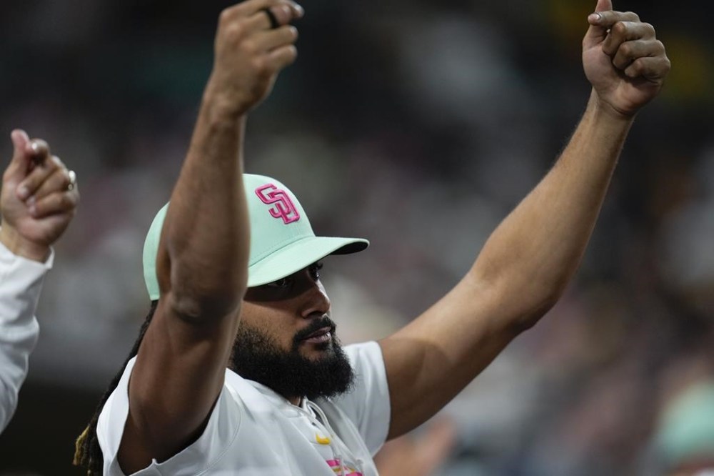 San Diego Padres's Fernando Tatis Jr. celebrates in the dugout after a single by teammate David Peralta during the seventh inning of a baseball game against the New York Mets, Friday, Aug. 23, 2024, in San Diego. (AP Photo/Gregory Bull)