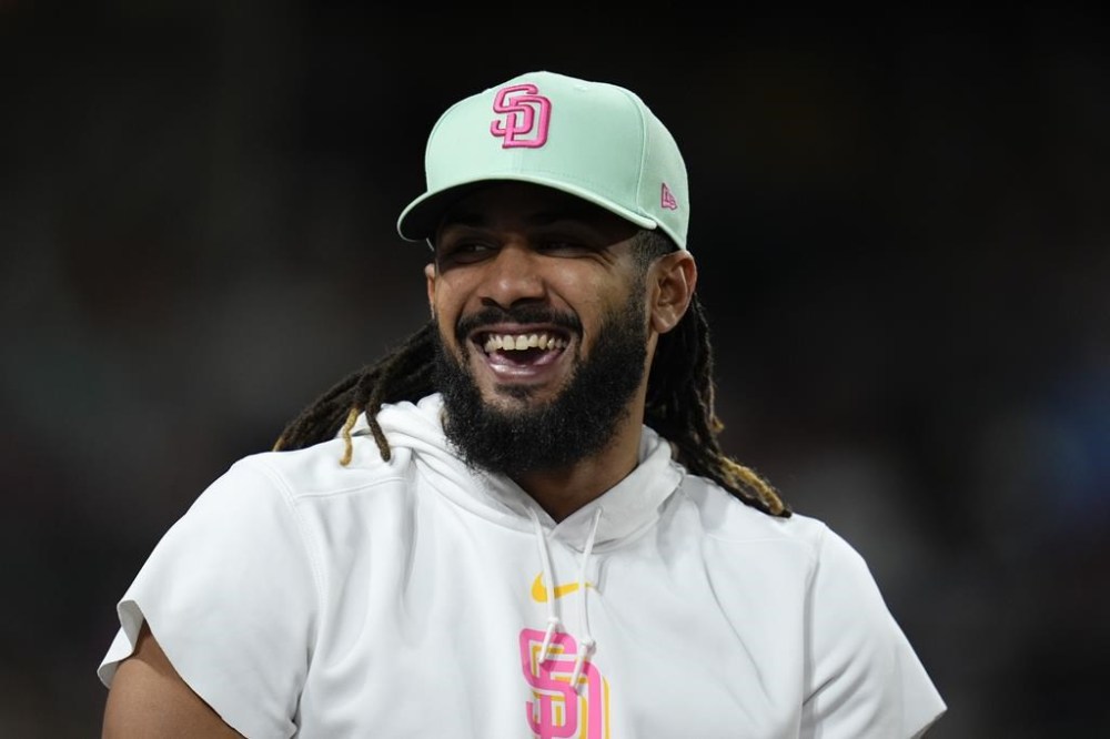 San Diego Padres's Fernando Tatis Jr. smiles in the dugout during the seventh inning of a baseball game against the New York Mets, Friday, Aug. 23, 2024, in San Diego. (AP Photo/Gregory Bull)