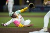 San Diego Padres starting pitcher Joe Musgrove tosses the ball with his glove to first baseman Jake Cronenworth for the out on New York Mets' Francisco Lindor during the sixth inning of a baseball game Friday, Aug. 23, 2024, in San Diego. (AP Photo/Gregory Bull)