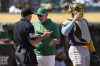 Oakland Athletics manager Mark Kotsay, middle, gestures while talking with umpire Dan Iassogna, left, as Milwaukee Brewers catcher William Contreras looks on during the seventh inning of a baseball game in Oakland, Calif., Saturday, Aug. 24, 2024. (AP Photo/Jeff Chiu)