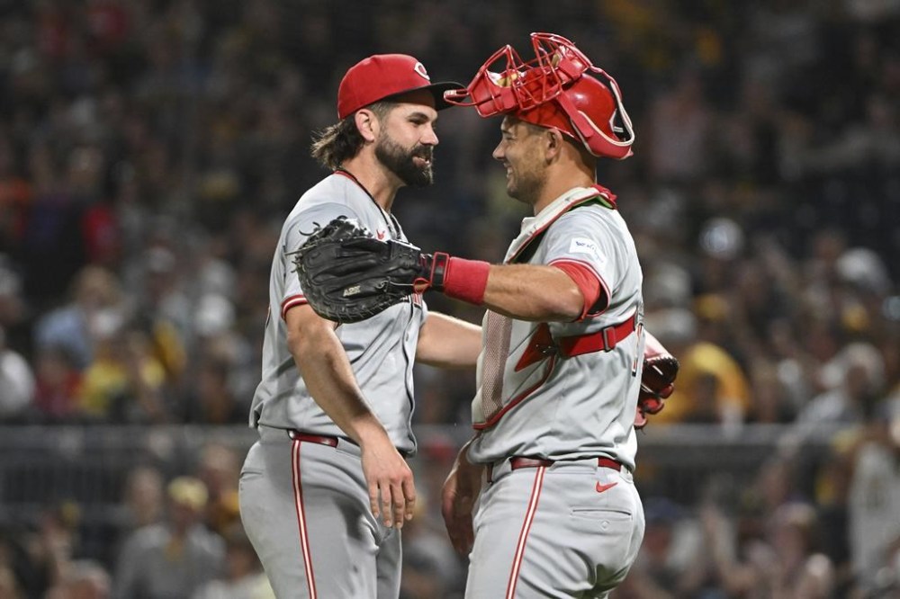 Cincinnati Reds relief pitcher Casey Kelly celebrates with catcher Luke Maile after defeating the Pittsburgh Pirates 10-2 during a baseball game, Saturday, Aug. 24, 2024, in Pittsburgh. (AP Photo/Barry Reeger)