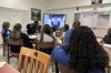 Parents and students in the Lackawanna City School District watch a video demonstrating a new policy that will require the students to lock their cellphones in pouches during the school day, Aug. 19, 2024, in Lackawanna, N.Y. (AP Photo/Carolyn Thompson)