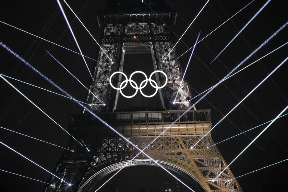 FILE -A light show is projected from the Eiffel Tower in Paris, France, during the opening ceremony of the 2024 Summer Olympics, July 26, 2024. (AP Photo/David J. Phillip, File)