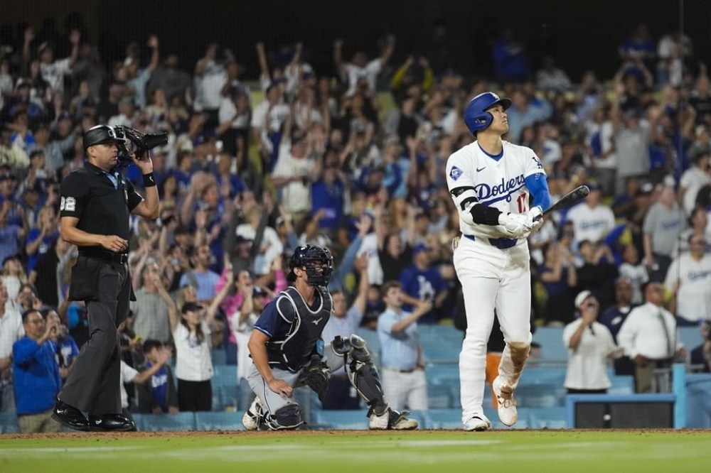 Los Angeles Dodgers designated hitter Shohei Ohtani (17) hits a grand slam during the ninth inning of a baseball game against the Tampa Bay Rays in Los Angeles, Friday, Aug. 23, 2024. The Dodgers won 7-3. Will Smith, Tommy Edman, and Max Muncy also scored. (AP Photo/Ashley Landis)