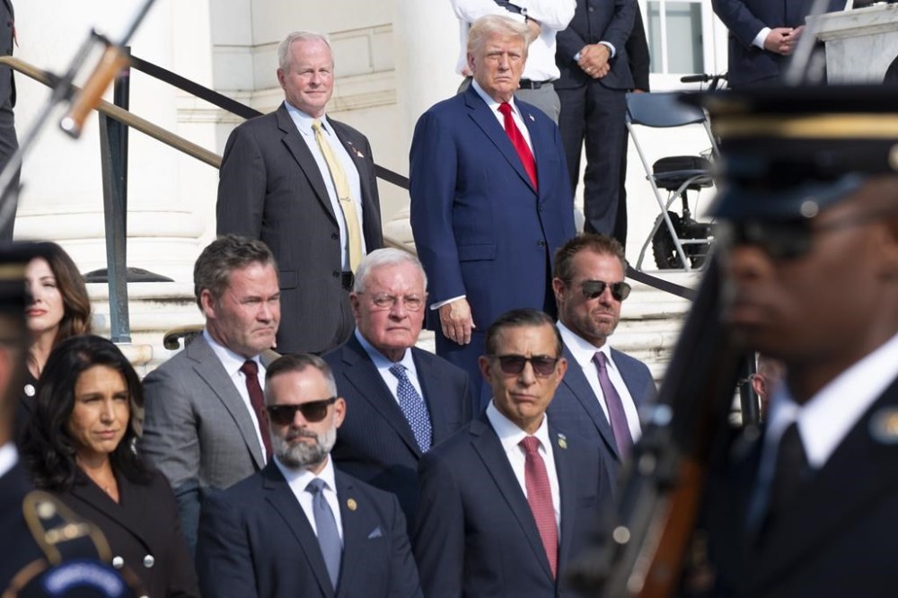 Bob Quackenbush, top left, deputy chief of staff for Arlington National Cemetery, and Republican presidential nominee former President Donald Trump watch the changing of the guard at the Tomb of the Unknown Solider with former Rep. Tulsi Gabbard of Hawaii, bottom left, Rep. Cory Mills, R-Fla., and Rep. Darrell Issa, R-Calif., at Arlington National Cemetery, Monday, Aug. 26, 2024, in Arlington, Va. (AP Photo/Alex Brandon)