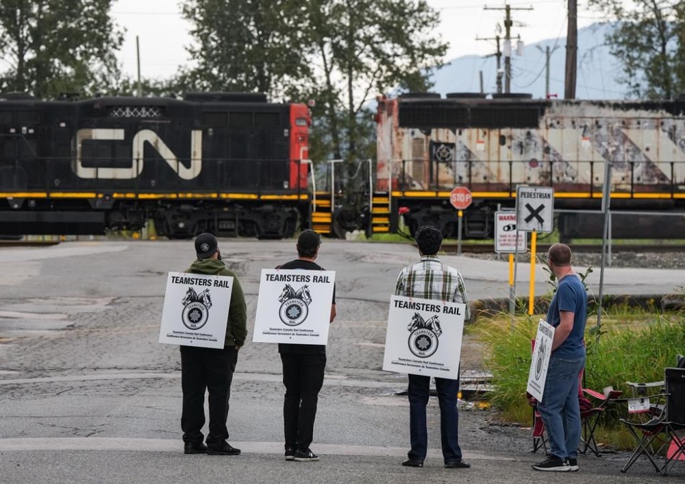 The shutdown at Canada's two major railways last week was not the first time a simultaneous work stoppage has brought trains to a halt. Locked-out Canadian National Rail workers stand at a picket line as locomotives are moved by management at CN Rail's Thornton Yard, in Surrey, B.C., Thursday, Aug. 22, 2024. THE CANADIAN PRESS/Darryl Dyck
