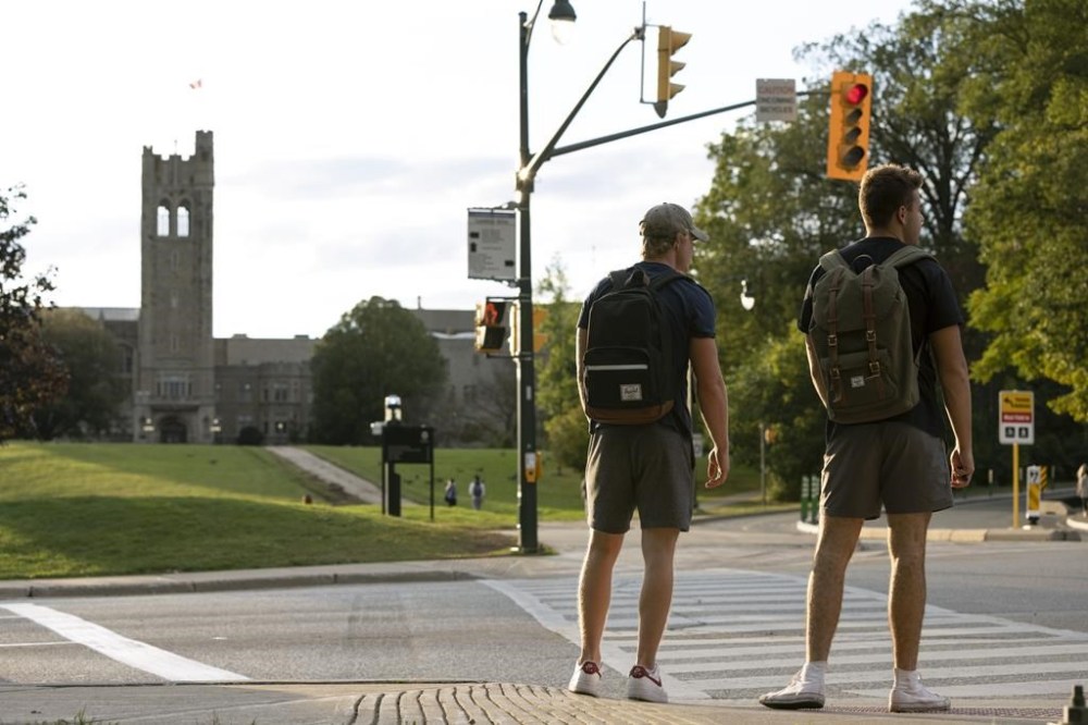 In a new survey from TD Bank, nearly half of Canadian students say they are unable to adequately cover basic needs such as food and housing. Students wait at a crosswalk at the Western University campus in London, Ont., Wednesday, Sept. 15, 2021. THE CANADIAN PRESS/Nicole Osborne