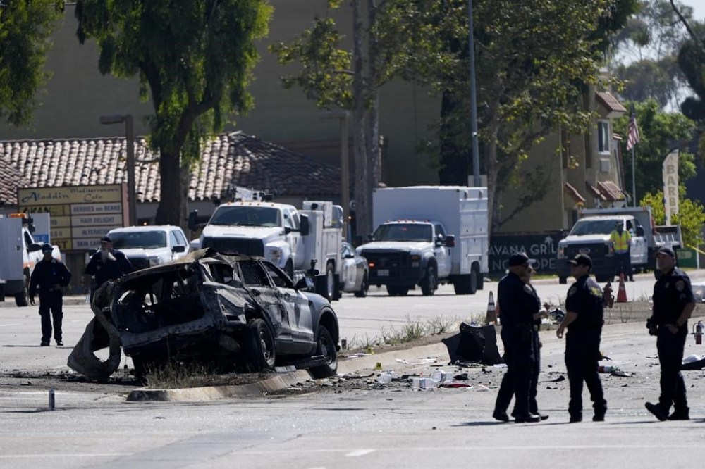 A charred police vehicle is seen in aftermath of an overnight crash which left an officer dead Tuesday, Aug. 27, 2024, in San Diego. (AP Photo/Gregory Bull)