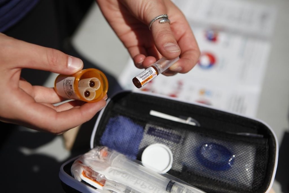 An organizer displays a naloxone kit in Victoria, B.C., on August 31, 2019. The British Columbia government is expanding access to drug-addiction treatment by launching a confidential and free phone line offering same-day connections to doctors and health-care professionals. THE CANADIAN PRESS/Chad Hipolito