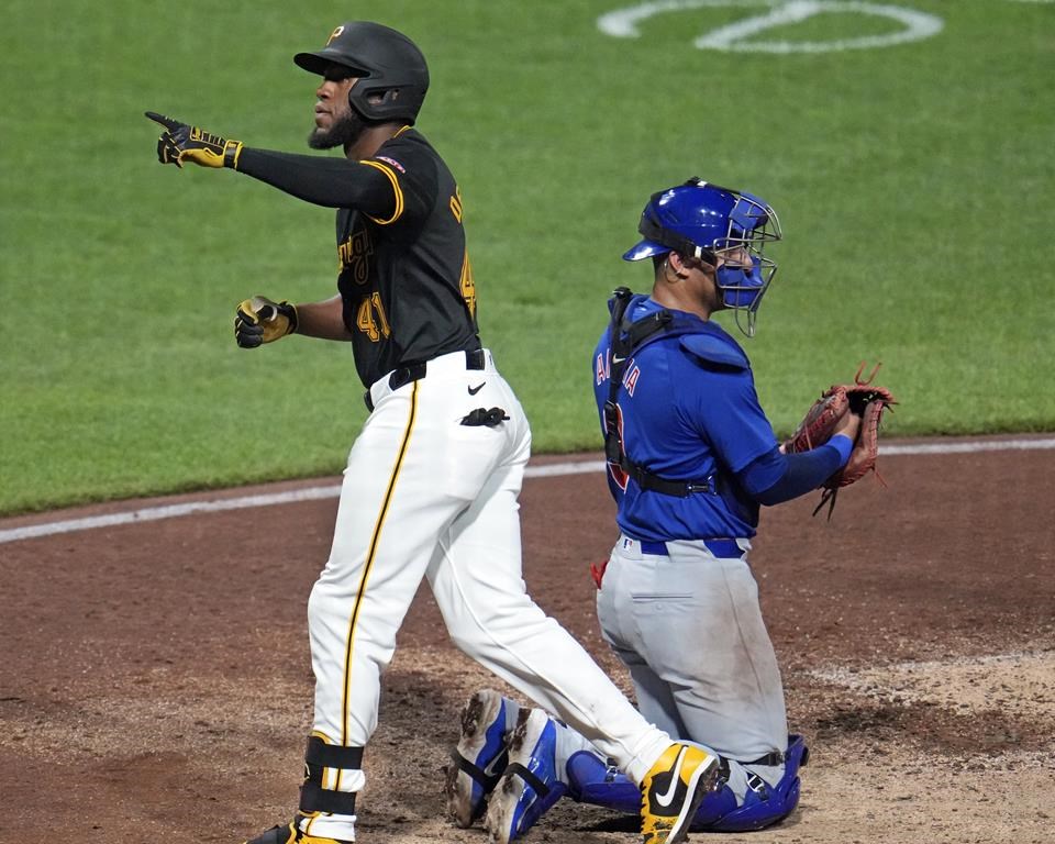 Pittsburgh Pirates' Bryan De La Cruz (41) heads back to the dugout past Chicago Cubs catcher Miguel Amaya after hitting a solo home run off relief pitcher Nate Pearson during the sixth inning of a baseball game in Pittsburgh, Tuesday, Aug. 27, 2024. (AP Photo/Gene J. Puskar)