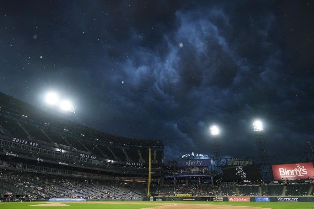 Dark clouds roll in over Guaranteed Rate field as it starts to rain during the first inning of a baseball game between the Texas Rangers and Chicago White Sox, Tuesday, Aug. 27, 2024, in Chicago. (AP Photo/Erin Hooley)