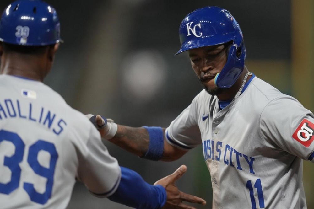 Kansas City Royals' Maikel Garcia, right, celebrates his single with first base coach Damon Hollins (39) in the seventh inning of a baseball game against the Cleveland Guardians, Tuesday, Aug. 27, 2024, in Cleveland. (AP Photo/Sue Ogrocki)