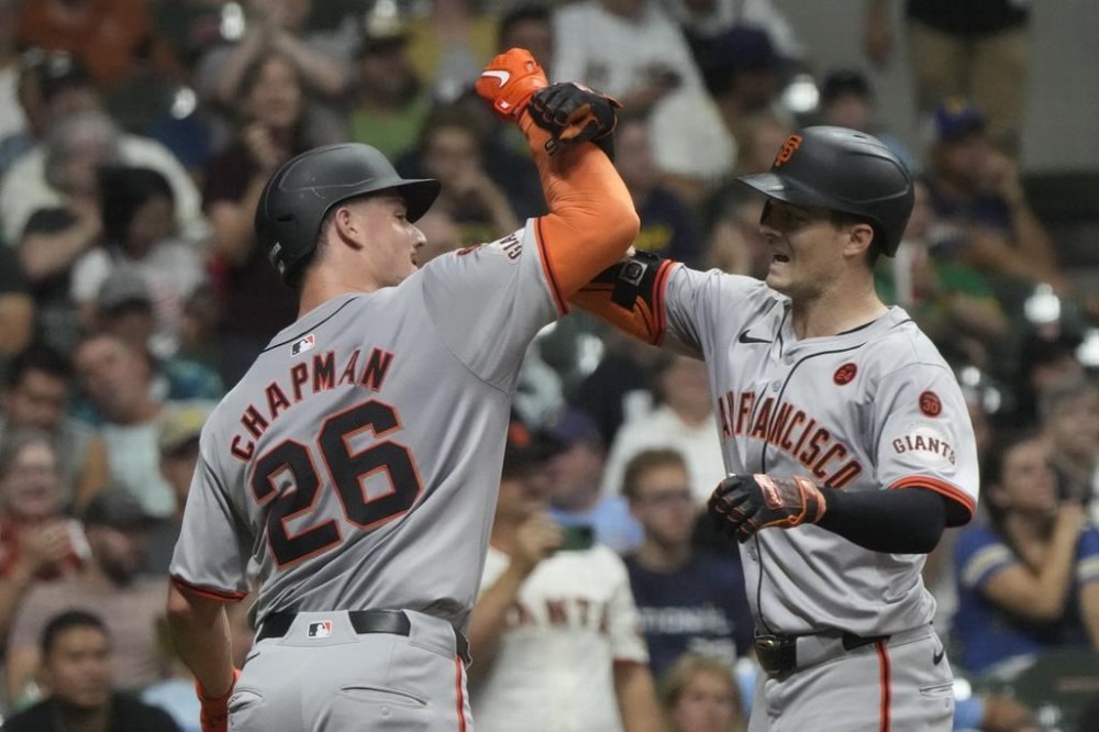 San Francisco Giants' Mike Yastrzemski is congratulated by Matt Chapman after hitting a two-run home run during the seventh inning of a baseball game against the Milwaukee Brewers Tuesday, Aug. 27, 2024, in Milwaukee. (AP Photo/Morry Gash)