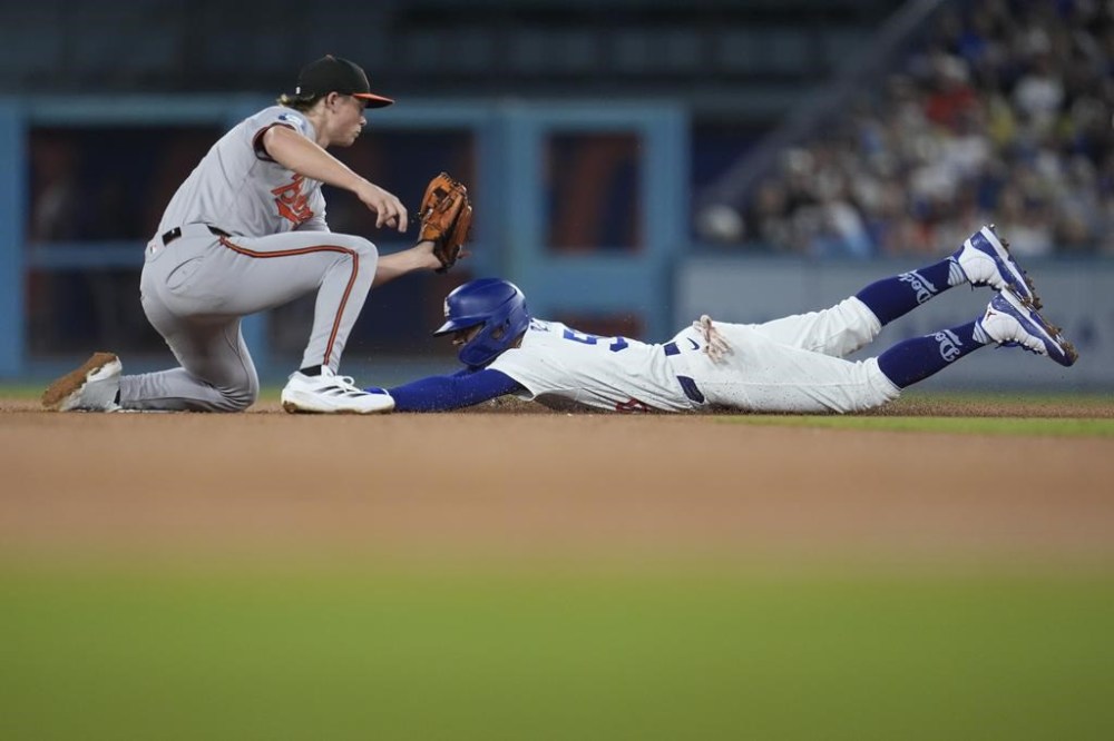 Los Angeles Dodgers' Mookie Betts, right, steals second base under the tag attempt from Baltimore Orioles second baseman Jackson Holliday during the eighth inning of a baseball game, Tuesday, Aug. 27, 2024, in Los Angeles. (AP Photo/Marcio Jose Sanchez)