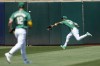 Oakland Athletics left fielder Miguel Andujar, right, catches a fly out hit by Milwaukee Brewers' Joey Ortiz as shortstop Max Schuemann (12) watches during the fourth inning of a baseball game in Oakland, Calif., Saturday, Aug. 24, 2024. (AP Photo/Jeff Chiu)