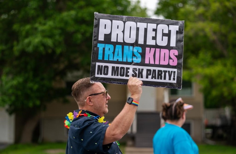 A person holds a sign during a pride parade in Regina, on Saturday, June 15, 2024. Regina school teacher Alex Schmidt says educators were confronted with different kinds of fears a year ago when Premier Scott Moe’s government introduced rules that require parental consent when children under 16 want to change their names or pronouns in school.THE CANADIAN PRESS/Heywood Yu