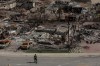 A worker walks in a devastated neighbourhood in west Jasper, Alberta on Monday August 19, 2024. A new study says planet-warming emissions from Canada's record-breaking wildfire season were quadruple the country's annual fossil emissions and on par with some of the largest global emitters. THE CANADIAN PRESS/Amber Bracken