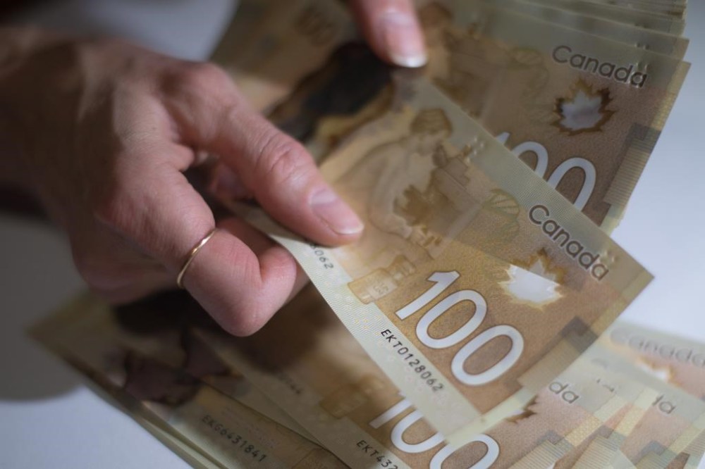 Canadian $100 bills are counted in Toronto, Feb. 2, 2016. Gaetano Gagliardi, government relations and policy lead for the National Payroll Institute, said a common misconception is that people