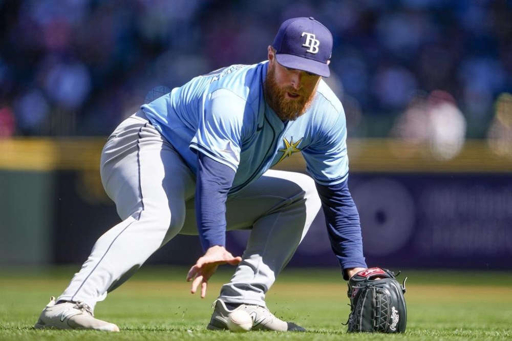 Tampa Bay Rays starting pitcher Drew Rasmussen looks to grab the ball hit by Seattle Mariners' Randy Arozarena before committing a throwing error that allowed Arozarena to advance to second base, during the second inning of a baseball game, Wednesday, Aug. 28, 2024, in Seattle. (AP Photo/Lindsey Wasson)