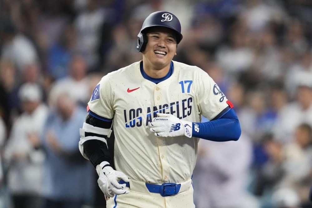 Los Angeles Dodgers designated hitter Shohei Ohtani (17) reacts after hitting a home run during the fifth inning of a baseball game against the Tampa Bay Rays in Los Angeles, Saturday, Aug. 24, 2024. Miguel Rojas also scored. (AP Photo/Ashley Landis)