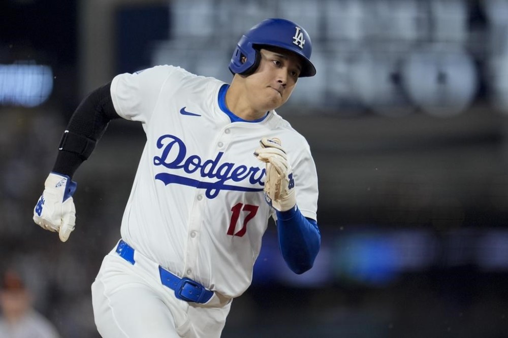 Los Angeles Dodgers' Shohei Ohtani runs rounds third base to score on a single from Teoscar Hernández during the third inning of a baseball game against the Baltimore Orioles, Tuesday, Aug. 27, 2024, in Los Angeles. (AP Photo/Marcio Jose Sanchez)