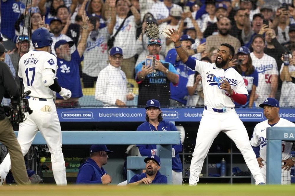 Los Angeles Dodgers' Shohei Ohtani, left, has sunflower seeds thrown at him by Teoscar Hernández after hitting a solo home run during the first inning of a baseball game against the Baltimore Orioles, Wednesday, Aug. 28, 2024, in Los Angeles. (AP Photo/Mark J. Terrill)