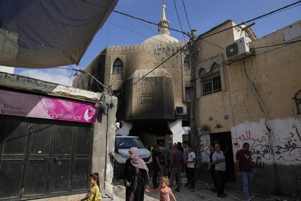 Palestinians stand outside a damaged mosque following an Israeli military operation in the West Bank refugee camp of Al-Faraa, Thursday, Aug. 29, 2024. (AP Photo/Nasser Nasser)