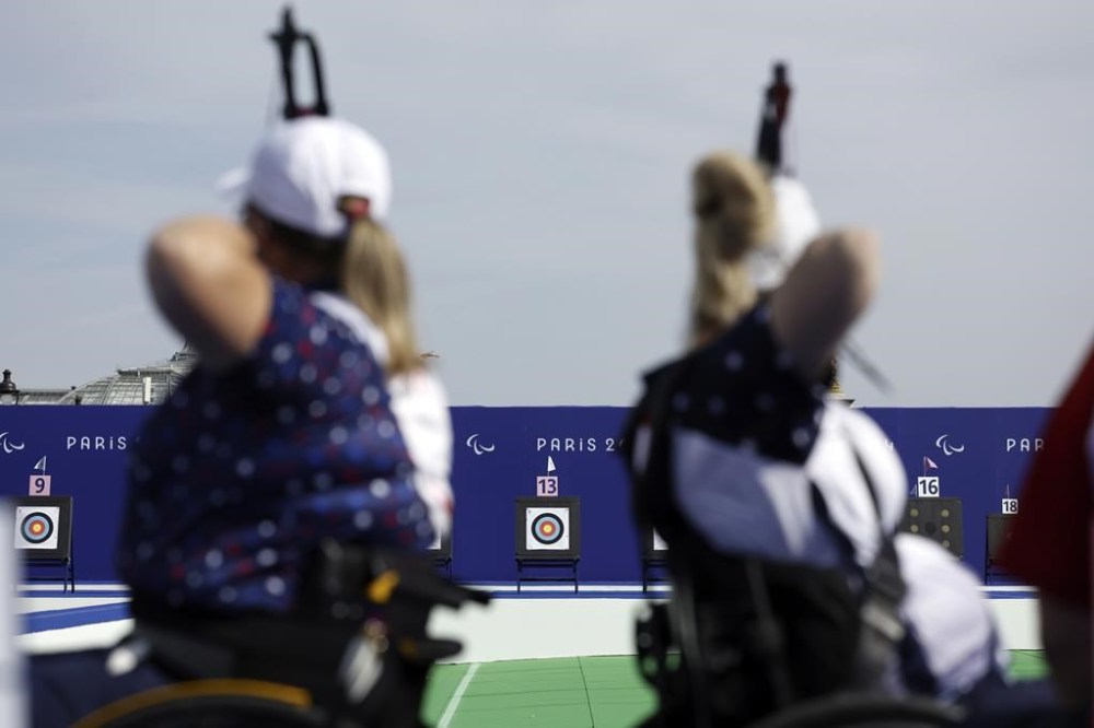Paralympian archers Sarka Musilova, of the Czech Republic, left, and Tracy Otto, from the U.S., prepare to fire during the Paralympic Games in Paris on Thursday, Aug. 29, 2024. (AP Photo/Felix Scheyer)