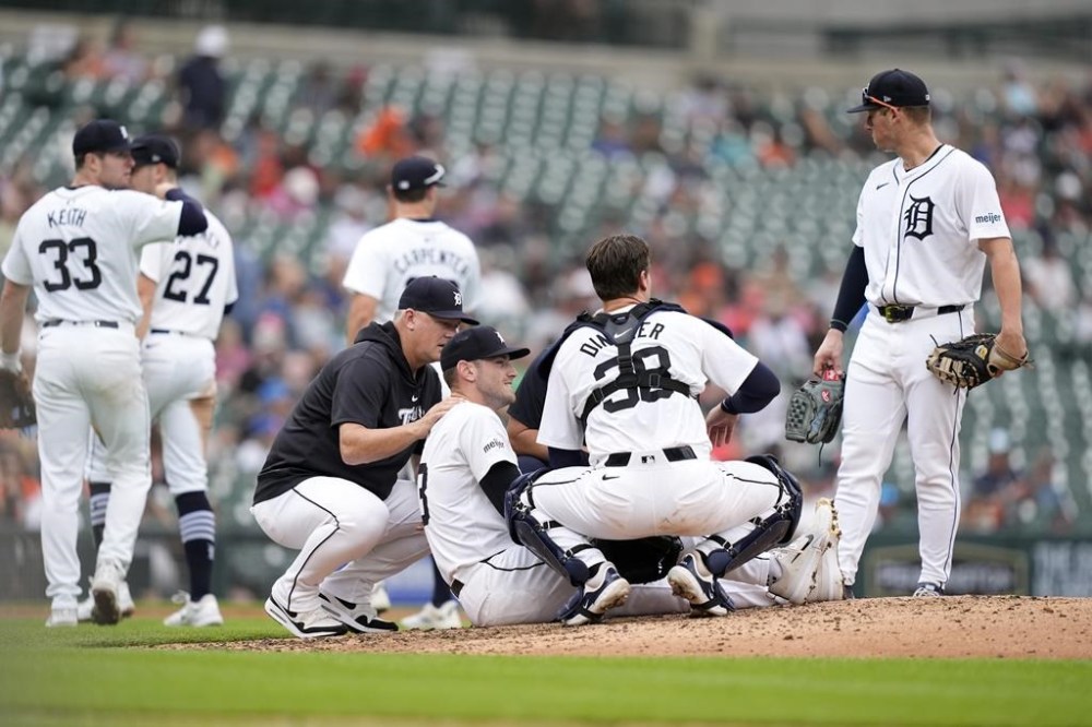 Detroit Tigers players look over pitcher Joey Wentz after a ground out hit to his right leg by Los Angeles Angels' Taylor Ward during the seventh inning of a baseball game, Thursday, Aug. 29, 2024, in Detroit. (AP Photo/Carlos Osorio)