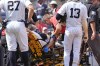 Medical staff tend to umpire Nick Mahrley (48) after he was hit by a bat during the fifth inning of a baseball game between the Colorado Rockies and the New York Yankees, Sunday, Aug. 25, 2024, in New York. (AP Photo/Bryan Woolston)